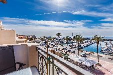 Terraza con vistas al puerto deportivo y embarcaciones, espacio exterior luminoso junto al mar